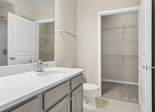 Kenzington bathroom with a white sink and toilet at Encore at Buckingham Apartments in Richardson, TX