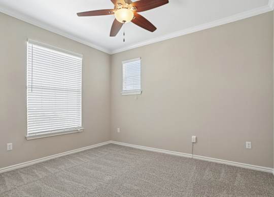 Kenzington bedroom with carpet and a ceiling fan at Encore at Buckingham Apartments in Richardson, TX