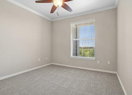 Kenzington bedroom with a carpet and ceiling fan at Encore at Buckingham Apartments in Richardson, TX
