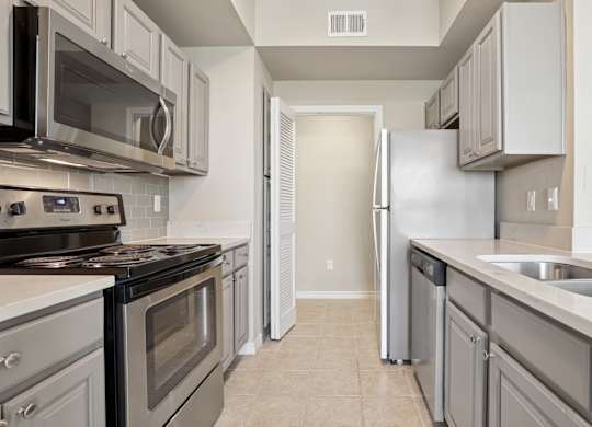 Kenzington kitchen with stainless steel appliances at Encore at Buckingham Apartments in Richardson, TX