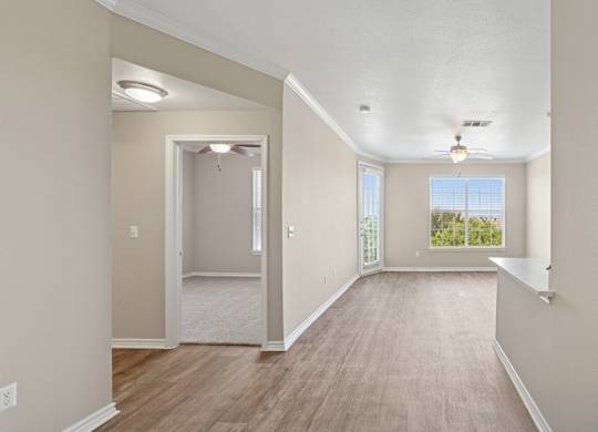 Kenzington living room with a carpeted floor and a ceiling fan at Encore at Buckingham Apartments in Richardson, TX