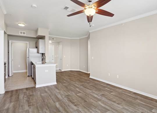 Kenzington living room with wood floors and a ceiling fan at Encore at Buckingham Apartments in Richardson, TX