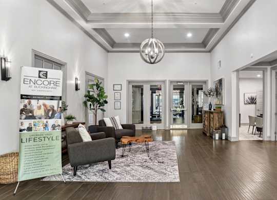 A leasing office with chairs and a rug at Encore at Buckingham Apartments in Richardson, TX