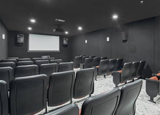 A movie theater with dark walls and speakers at Encore at Buckingham Apartments in Richardson, TX