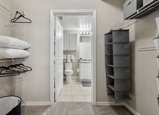 Windsor white bathroom with a walk in closet at Encore at Buckingham Apartments in Richardson, TX