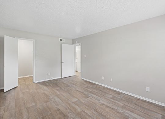 A room with wood flooring and white walls.