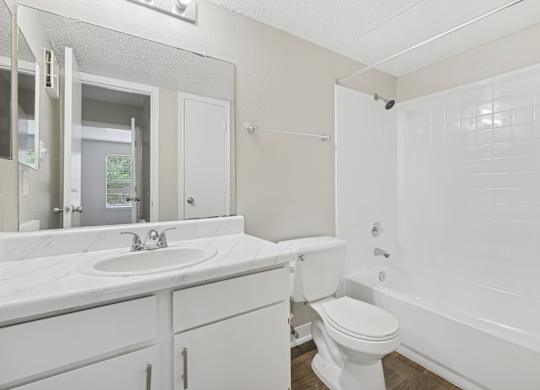 A white bathroom with a toilet, sink, and bathtub.