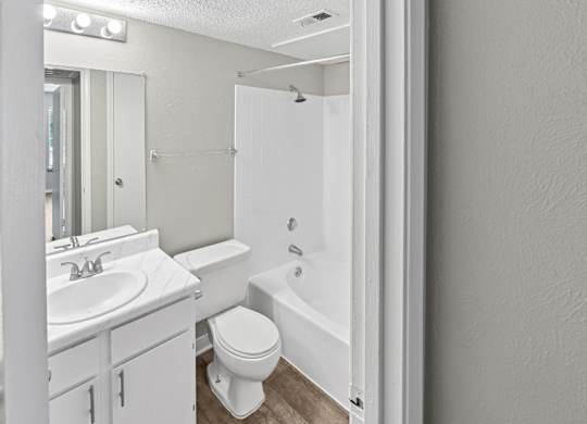 A white bathroom with a toilet, sink, and bathtub.