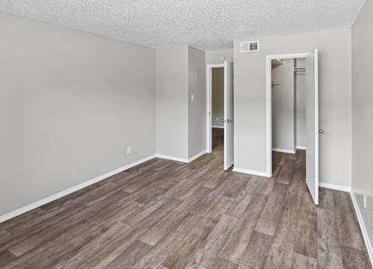 A room with wood flooring and white walls.