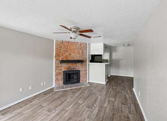 A room with a fireplace and a ceiling fan.