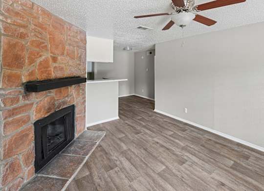 A room with a fireplace and a ceiling fan.