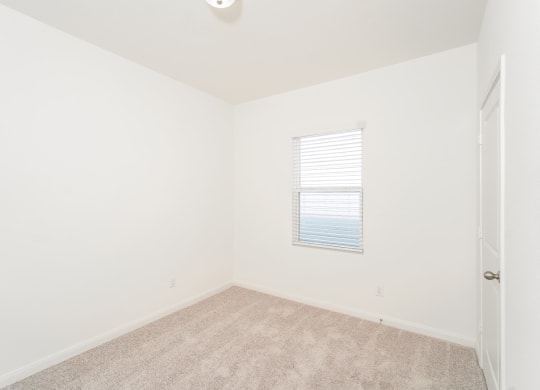 a bedroom with white walls and carpet at Beacon at Meridian, San Antonio, 78245