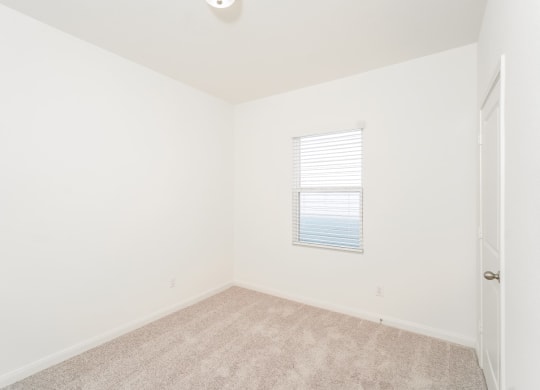 a bedroom with white walls and carpet