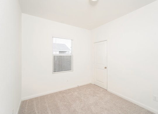 a bedroom with white walls and carpet