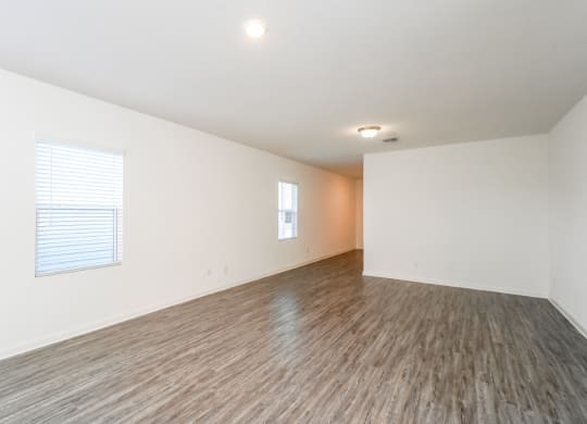 a bedroom with hardwood floors and white walls