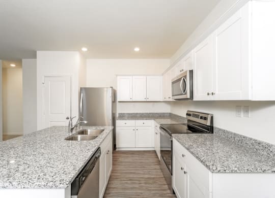 a kitchen with white cabinets and granite countertops