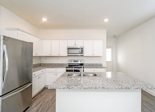a kitchen with white cabinets and a granite counter top