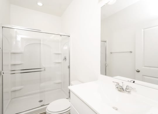 a bathroom with a white sink and toilet next to a glass shower at Beacon at Meridian, San Antonio, 78245
