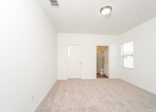 a bedroom with white walls and carpet