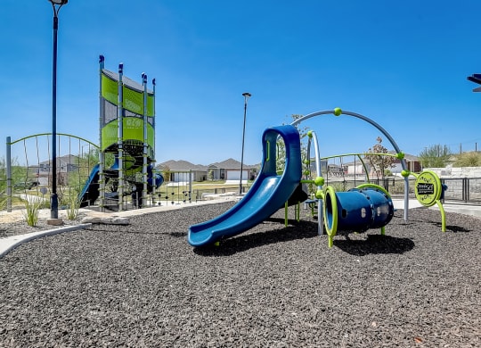 a playground with a blue slide and green playset at Beacon at Meridian, Texas