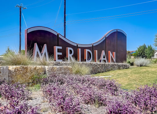 a sign that says meridian with purple flowers in front of it at Beacon at Meridian, Texas, 78245