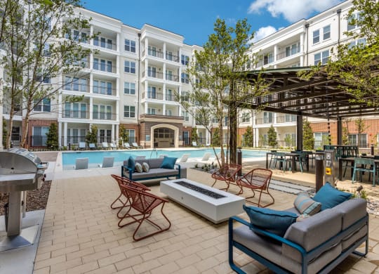 Outdoor seating around the fire pit by the pool at Era Apartments in Denton, TX