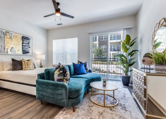 Model Studio apartment living room with a bed and a couch at Era Apartments in Denton, TX