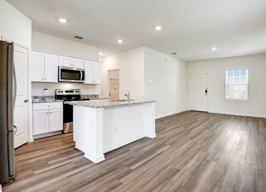 a kitchen and living room with hardwood floors and white walls at Beacon at Meridian, San Antonio Texas