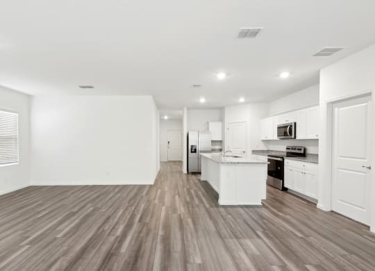 a living area with white walls and hardwood floors