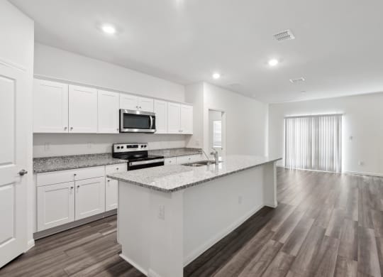kitchen with marble countertop and white cabinets within a spacious living area