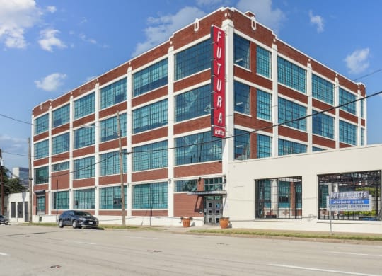 a large brick building with a red sign on the side of it