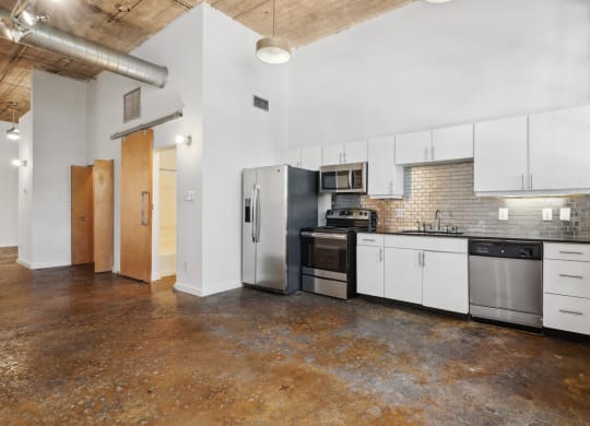 Futura Lofts kitchen with white cabinets and stainless steel appliances | Deep Ellum Lofts in Dallas, TX