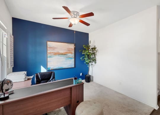 an office with a blue accent wall and a ceiling fan at Beacon at Meridian, San Antonio, TX