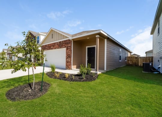 a home with a tree in the front yard at Beacon at Meridian, Texas, 78245