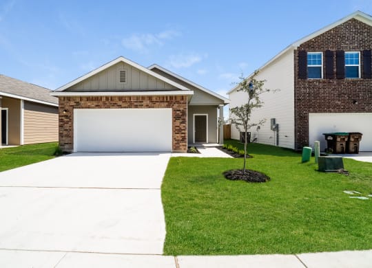 a house with a white garage door in front of a green lawn at Beacon at Meridian, San Antonio