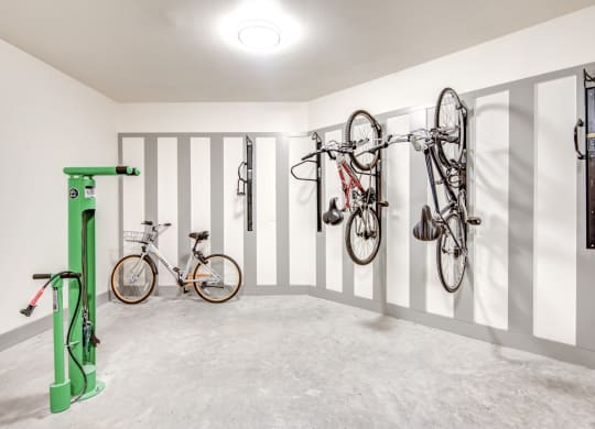 two bikes hanging on the wall in a room with white walls
