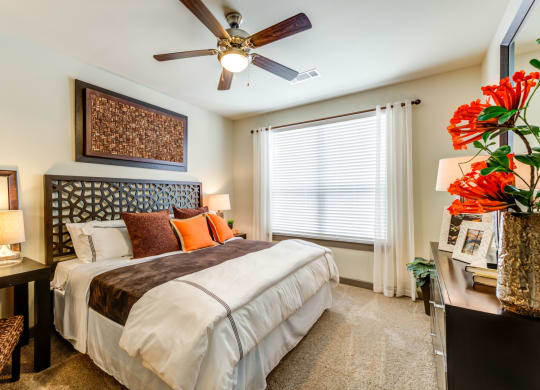 a bedroom with a large bed and a ceiling fan