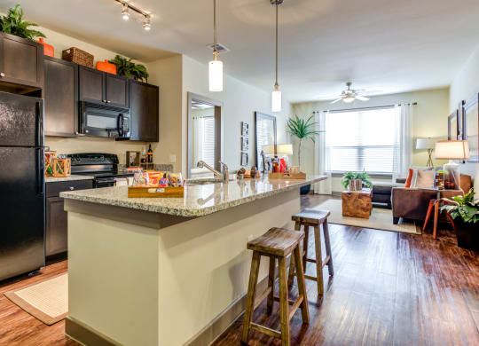 an open kitchen with a large island with bar stools