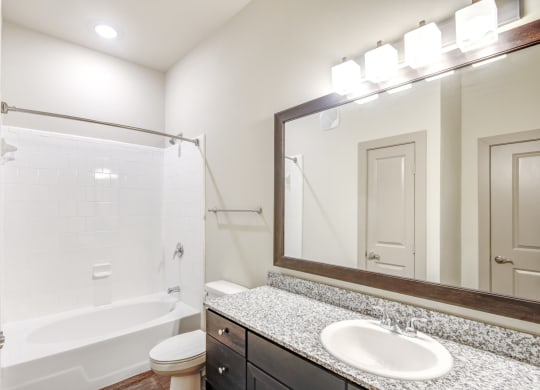 a bathroom with a shower and a sink and a mirror