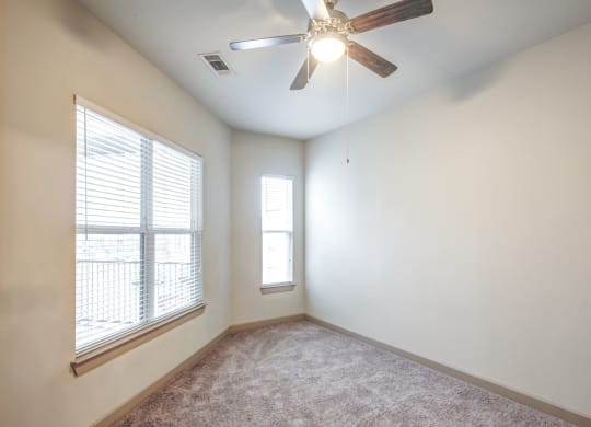 a living room with a large window and a ceiling fan