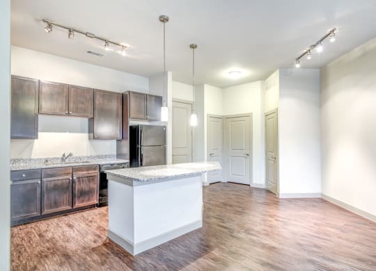 an open kitchen and living room with a large island and wood flooring