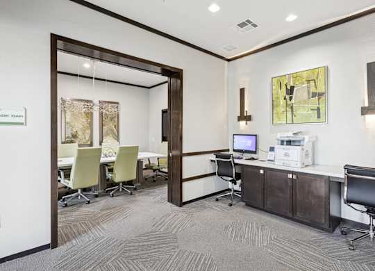 A business center with a computer, printer, and conference room at GreenVue Apartments in Richardson, TX