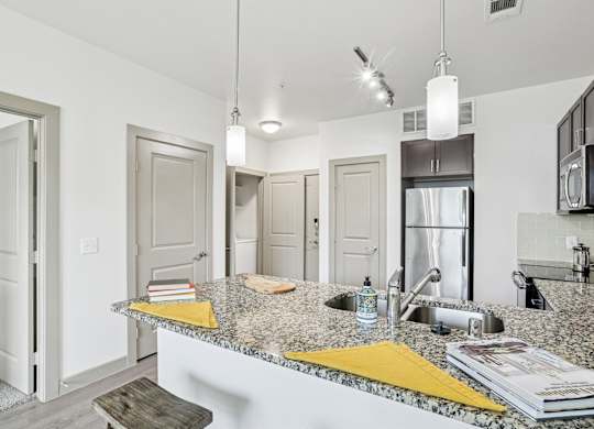 A kitchen with granite countertops and stainless steel appliances at GreenVue Apartments in Richardson, TX