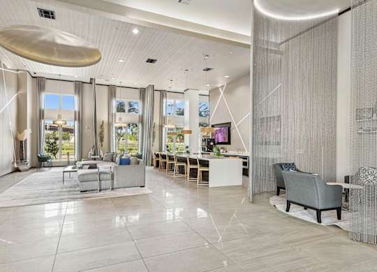 Spacious clubhouse with large windows, televisions, and couches at GreenVue Apartments in Richardson, TX