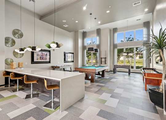 Game room with pool table, air hockey, and more at GreenVue apartments in Richardson, TX