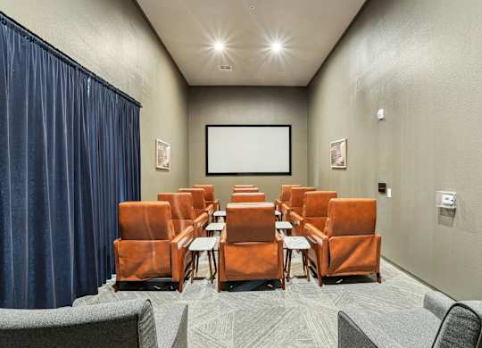 Movie room with theatre style chairs and a projector screen at GreenVue apartments in Richardson, TX