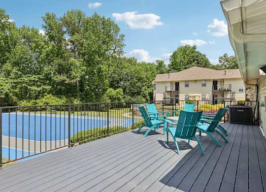 A deck with a table and chairs overlooking a basketball court at Gwinnett Square Apartments in Duluth, GA