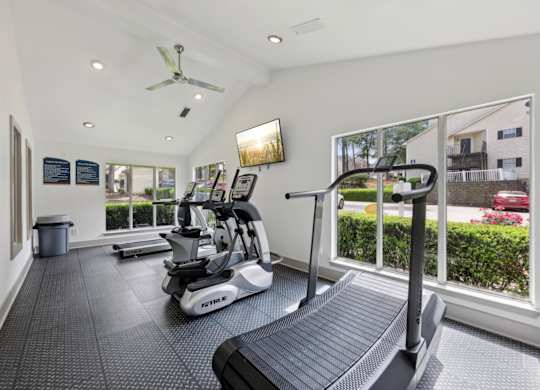 A fitness center with treadmills and ellipticals at Gwinnett Square Apartments in Duluth, GA