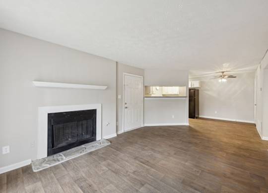 A living room with a fireplace and wood flooring at Gwinnett Square Apartments in Duluth, GA