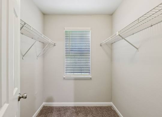A white closet with a window and a carpeted floor at Gwinnett Square Apartments in Duluth, GA